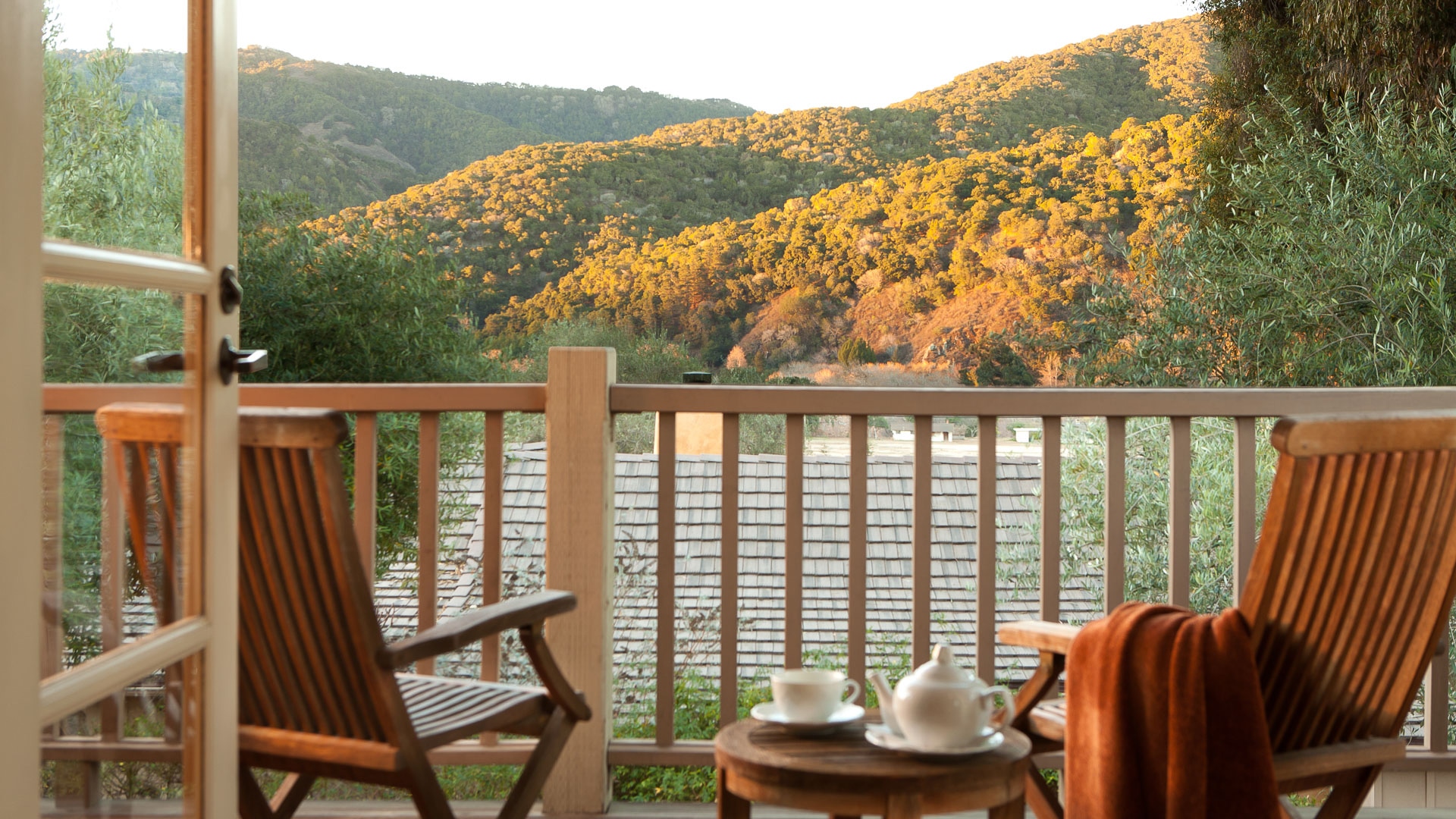 a tea set on a deck overlooking a mountain range