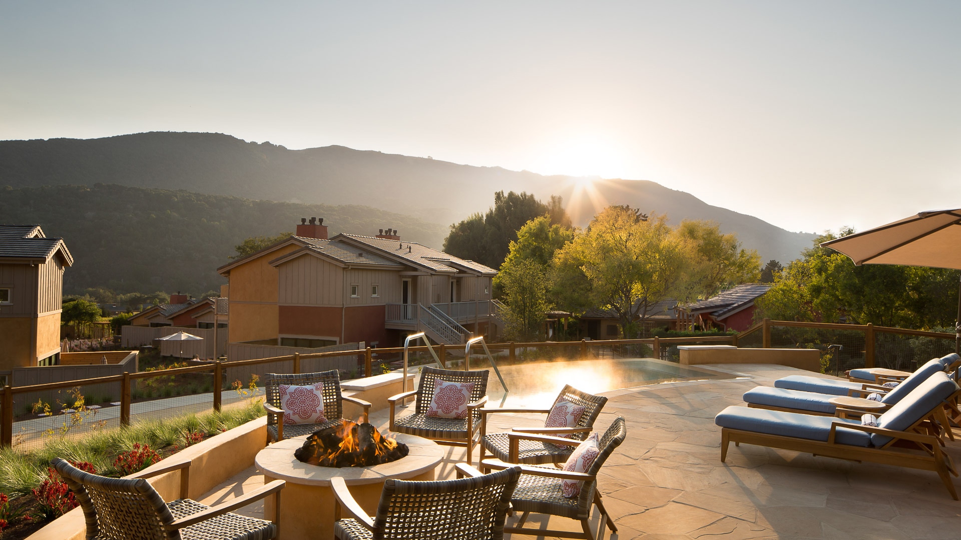 a patio with chairs and a fire pit