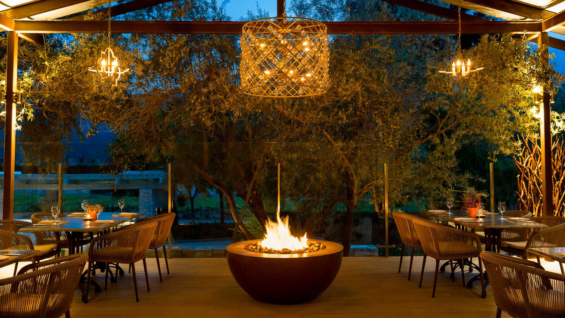 a fire pit with chairs and a chandelier