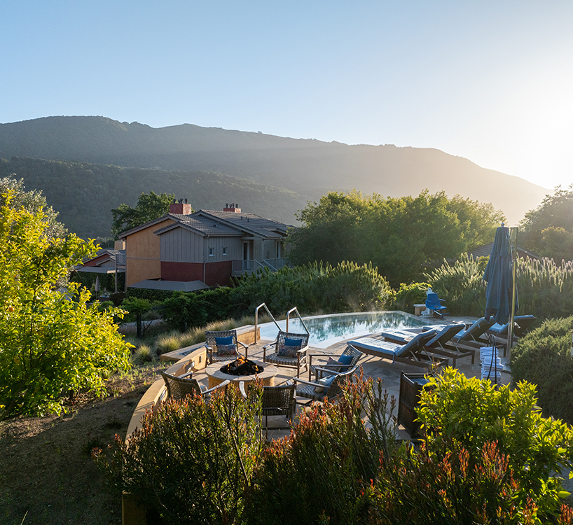a pool with chairs and a house in the background