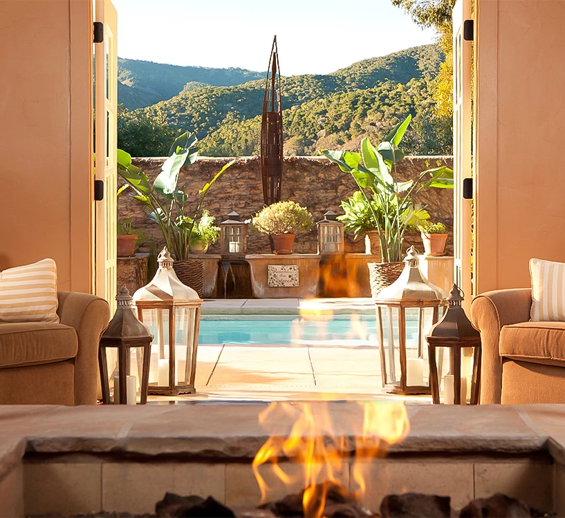 a fire in a room with a fireplace and chairs