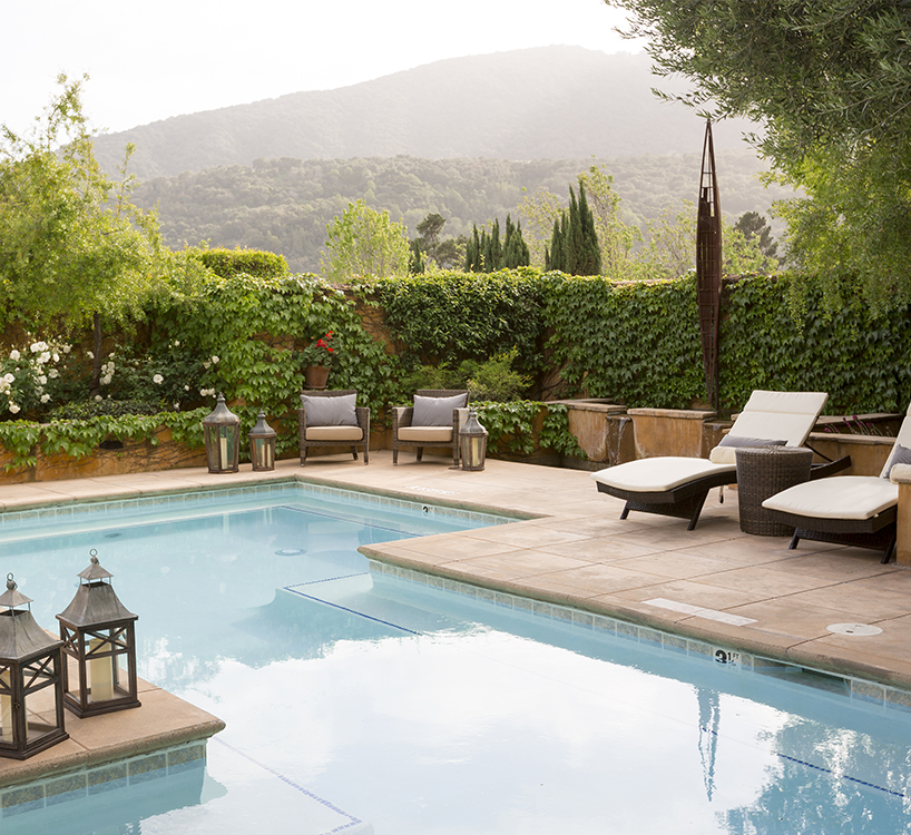 a pool with chairs and a mountain in the background