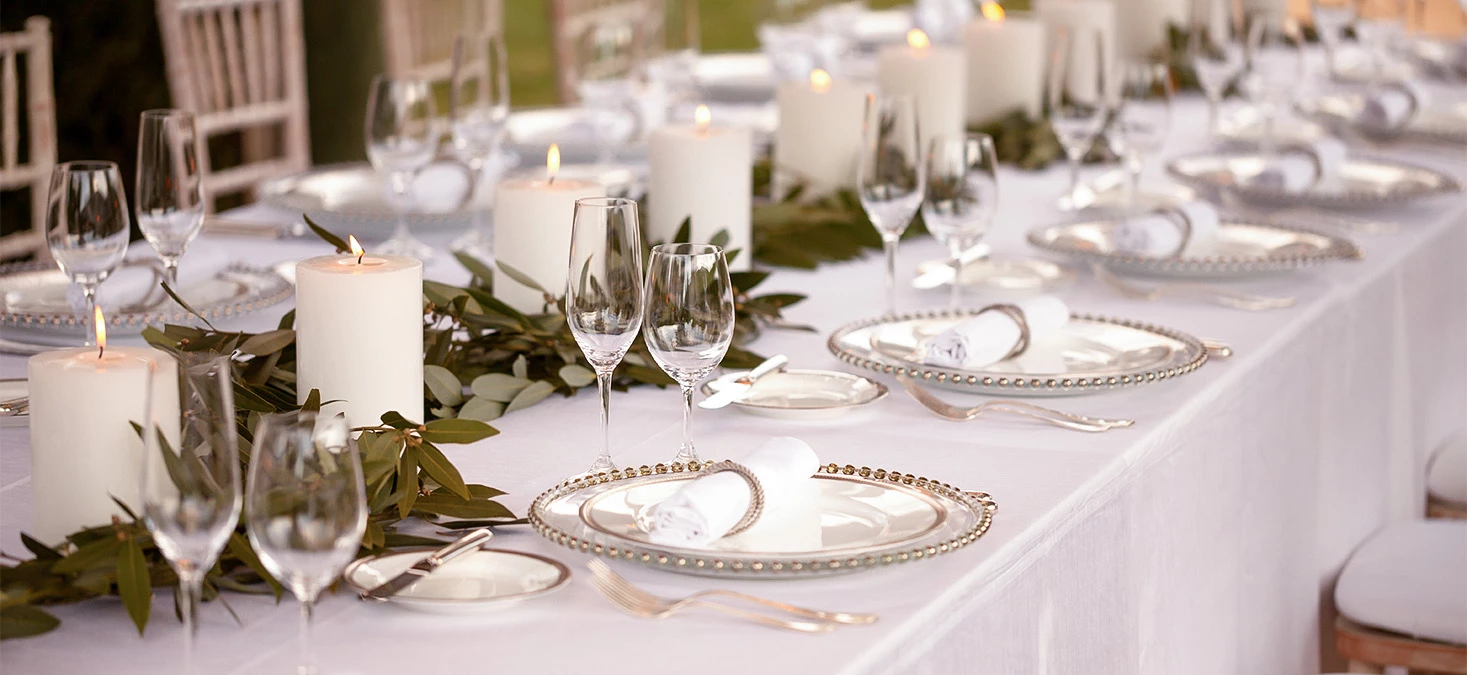 a table with plates and glasses and candles