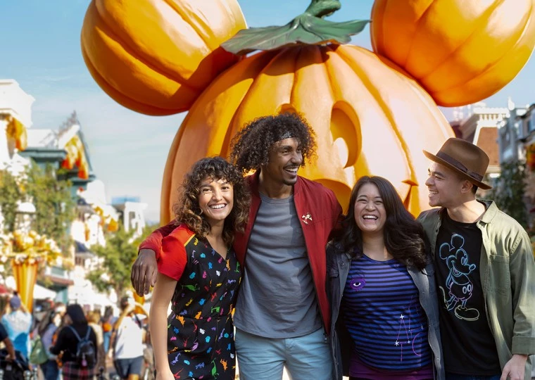 a group of people posing for a photo in front of a large pumpkin