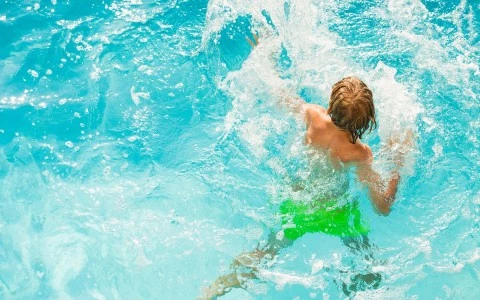 young boy playing in the pool
