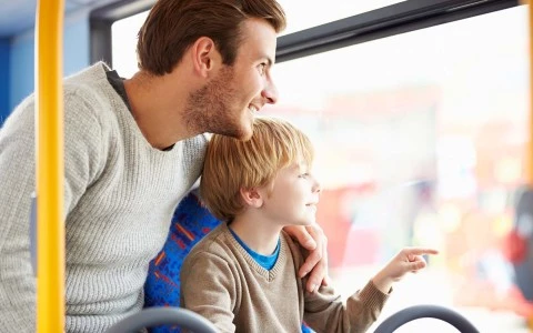 father and son looking out of a bus window