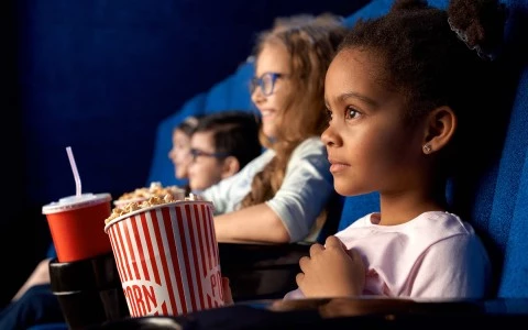 4 kids in a theater watching a movie