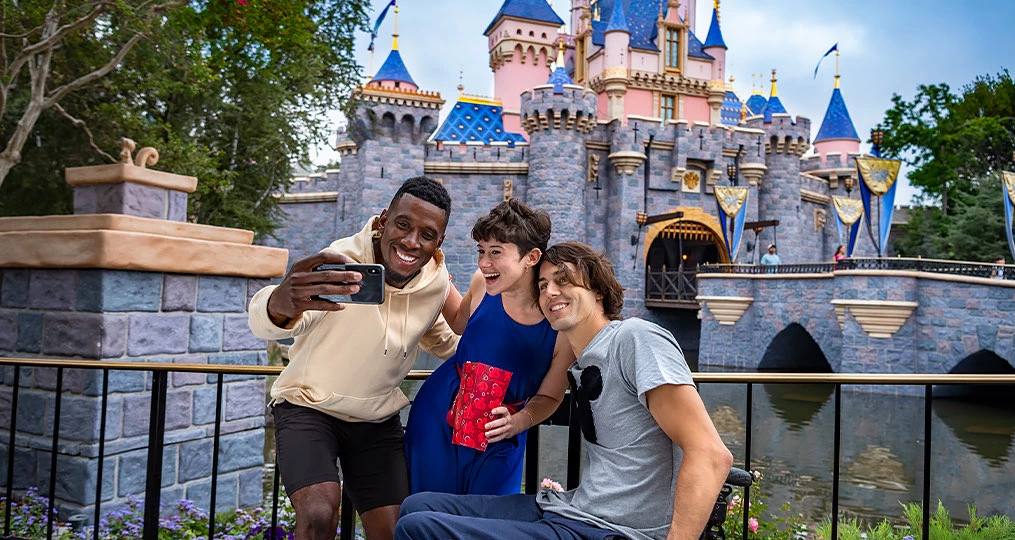 group of three friends taking a photo in front of the castle