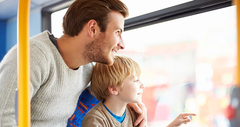 father and son on a bus looking outside
