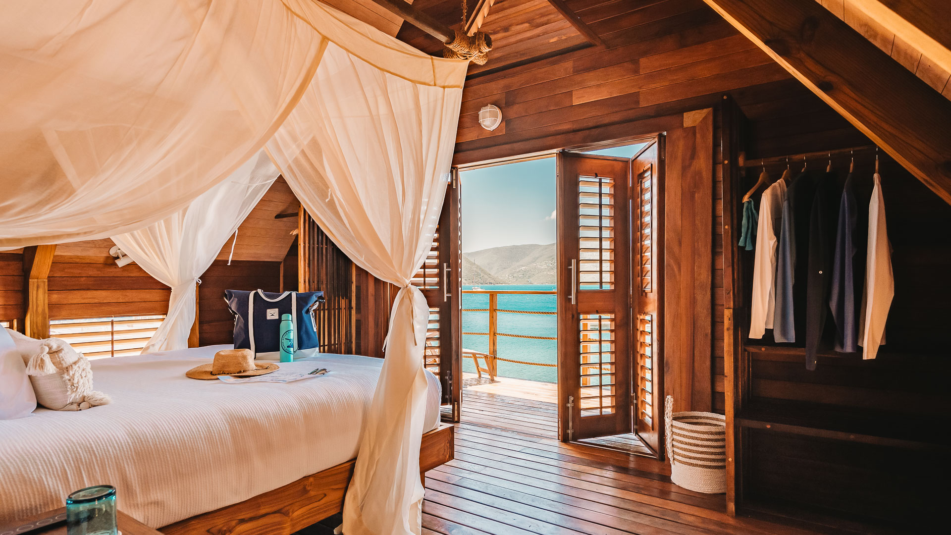 a room with a bed and a canopy over a wooden deck