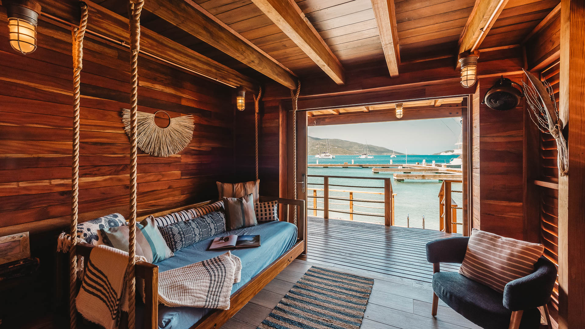 a porch with a swing and a view of the water