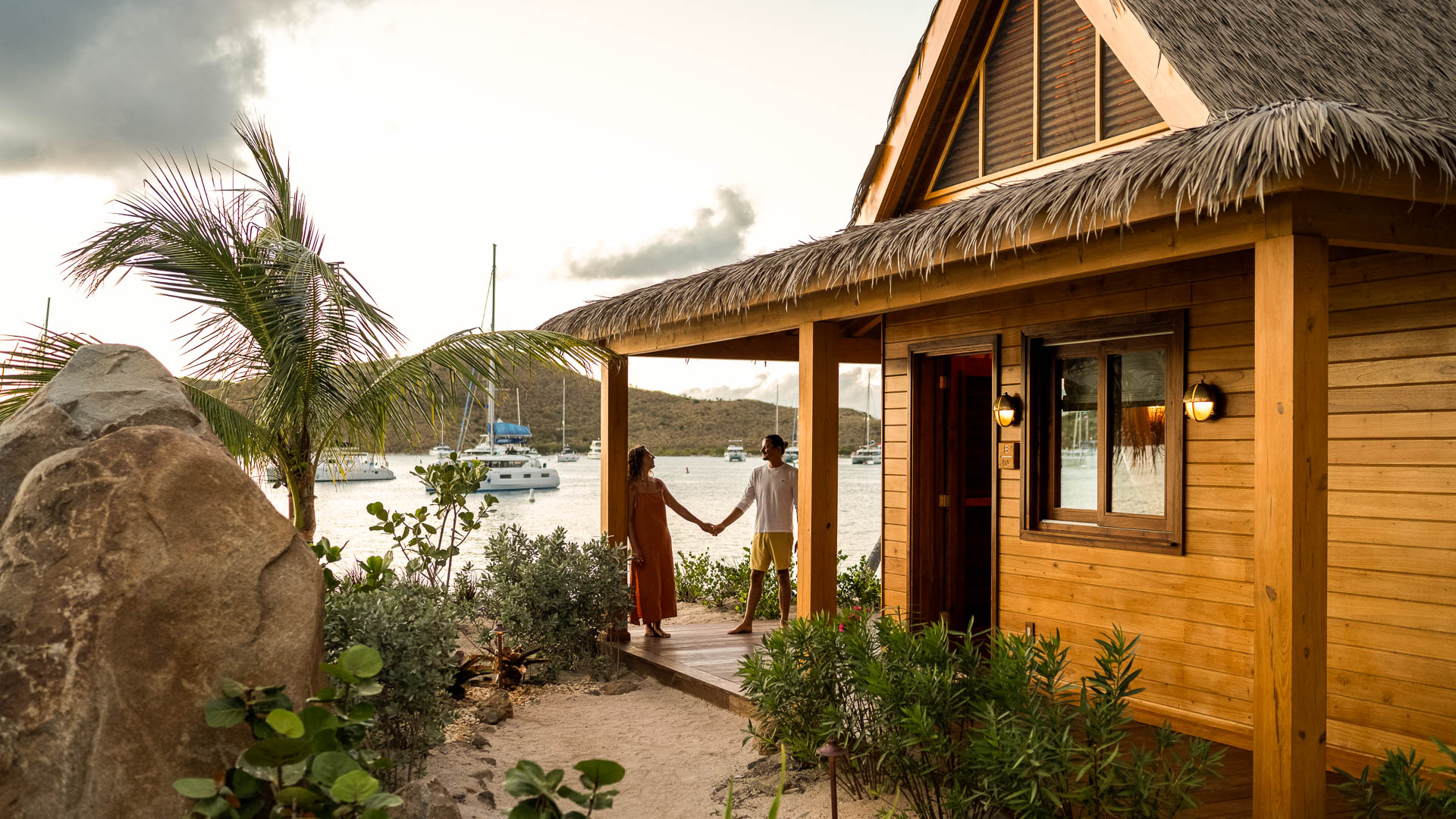 a man and woman holding hands in front of a house