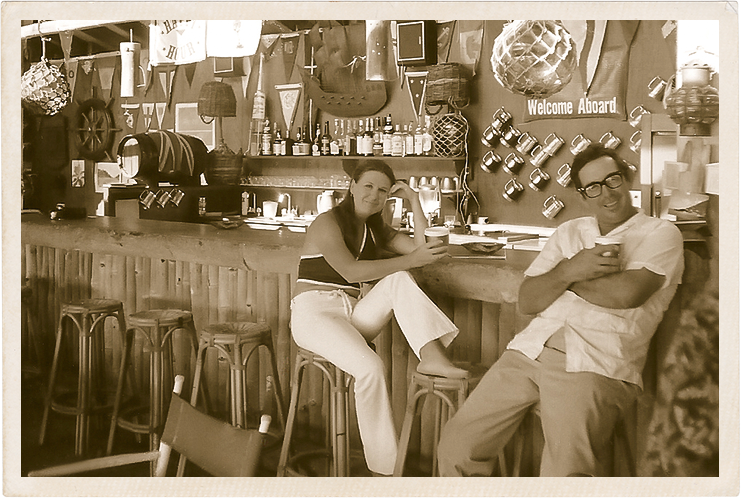 a man and woman sitting at a bar