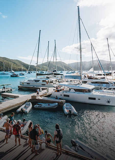 a group of people standing on a dock with boats and a group of people