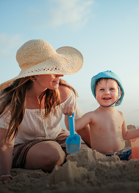 a woman and child playing in sand