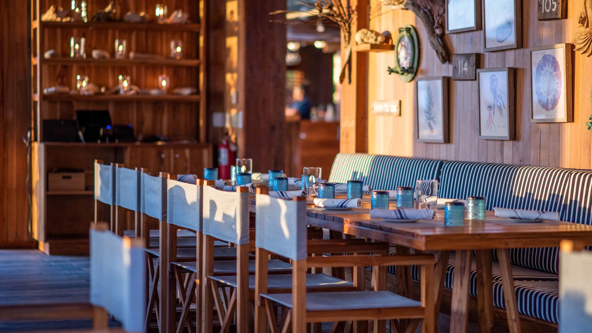 a table with blue and white striped chairs and blue glasses