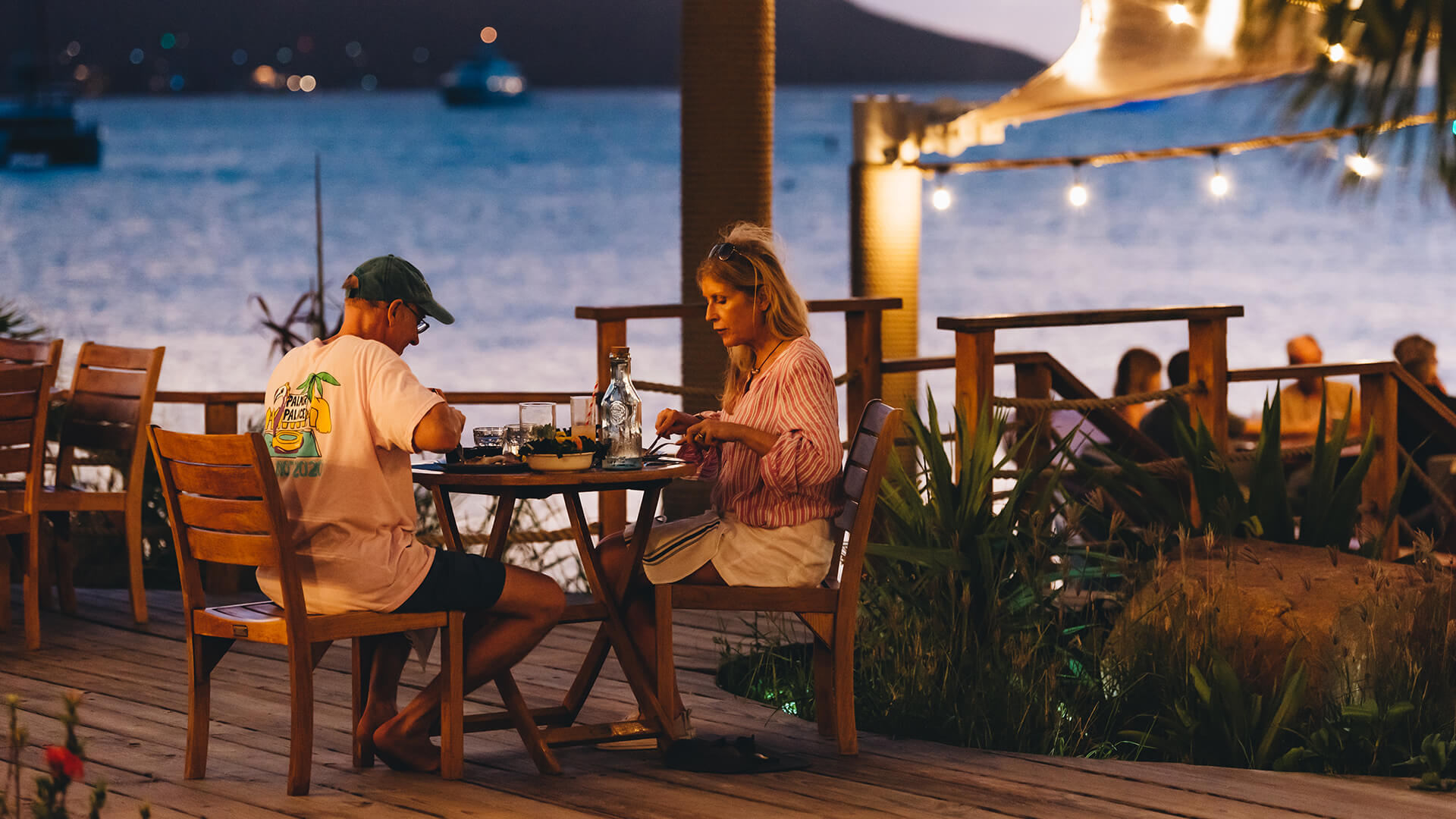 a man and woman sitting at a table outside
