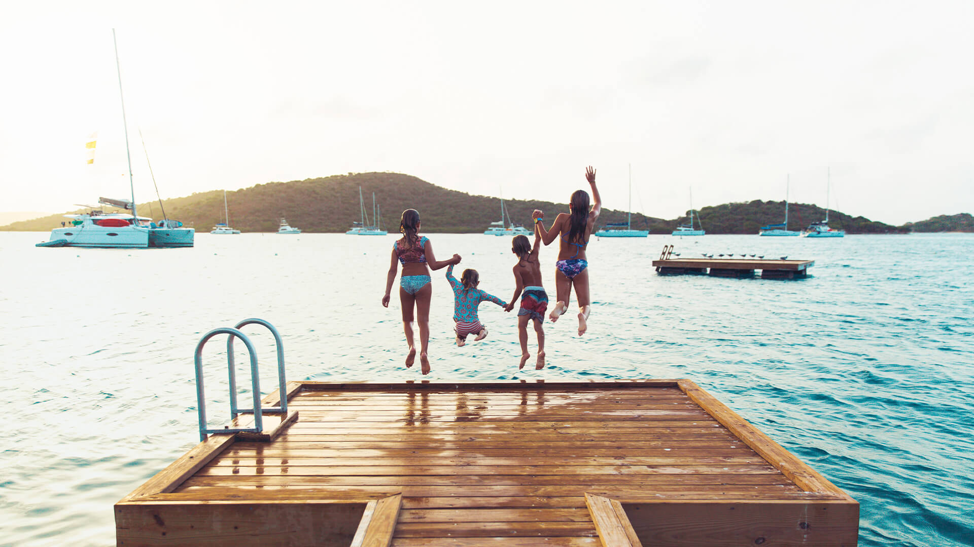 a group of children jumping into the water