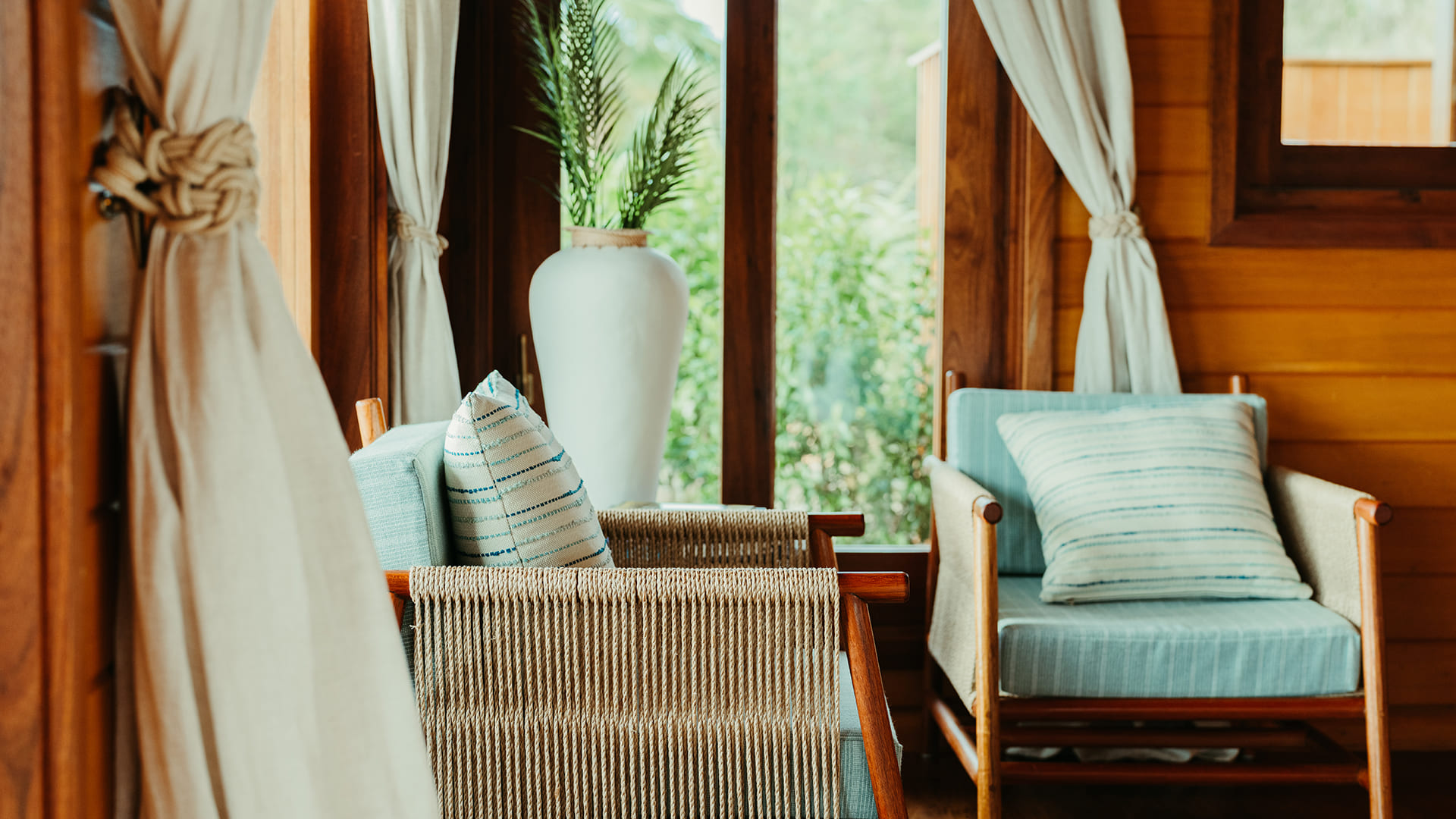 a chair in a room with a vase of plants