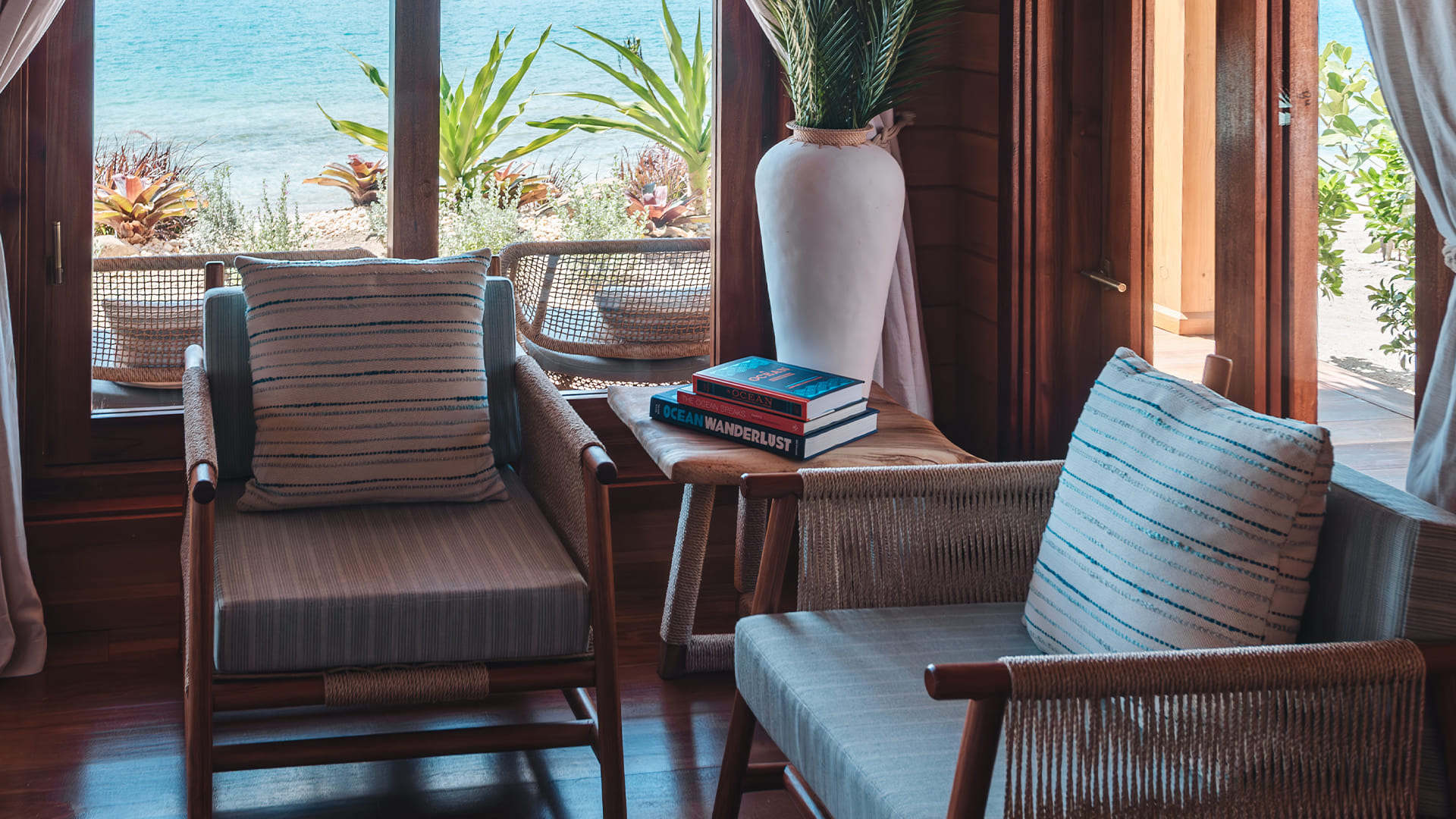 a room with chairs and a vase of plants