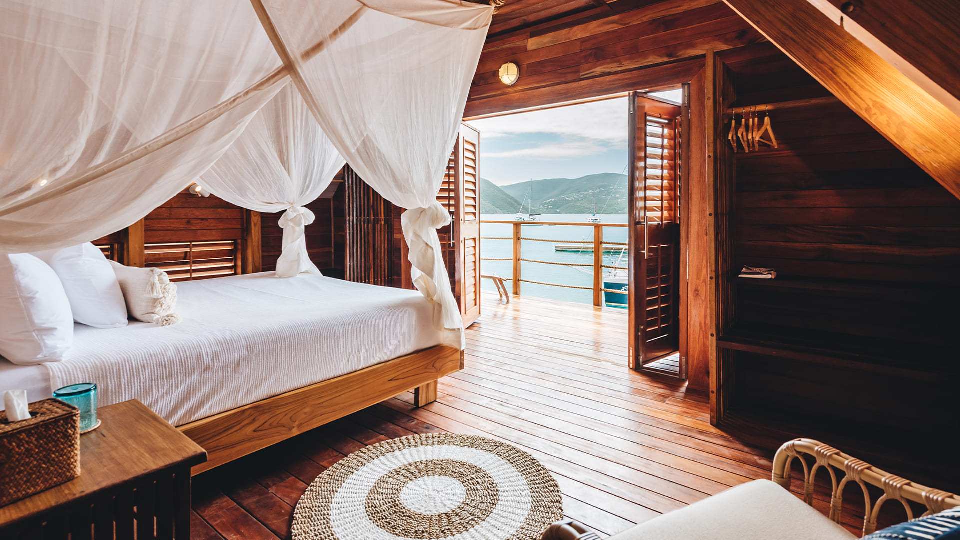 a room with a bed and a view of the ocean