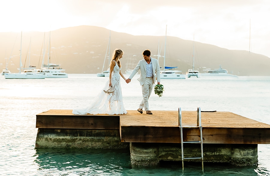 a man and woman holding hands on a dock