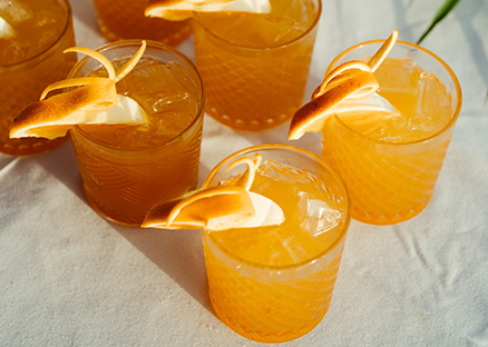 a group of glasses with oranges and ice