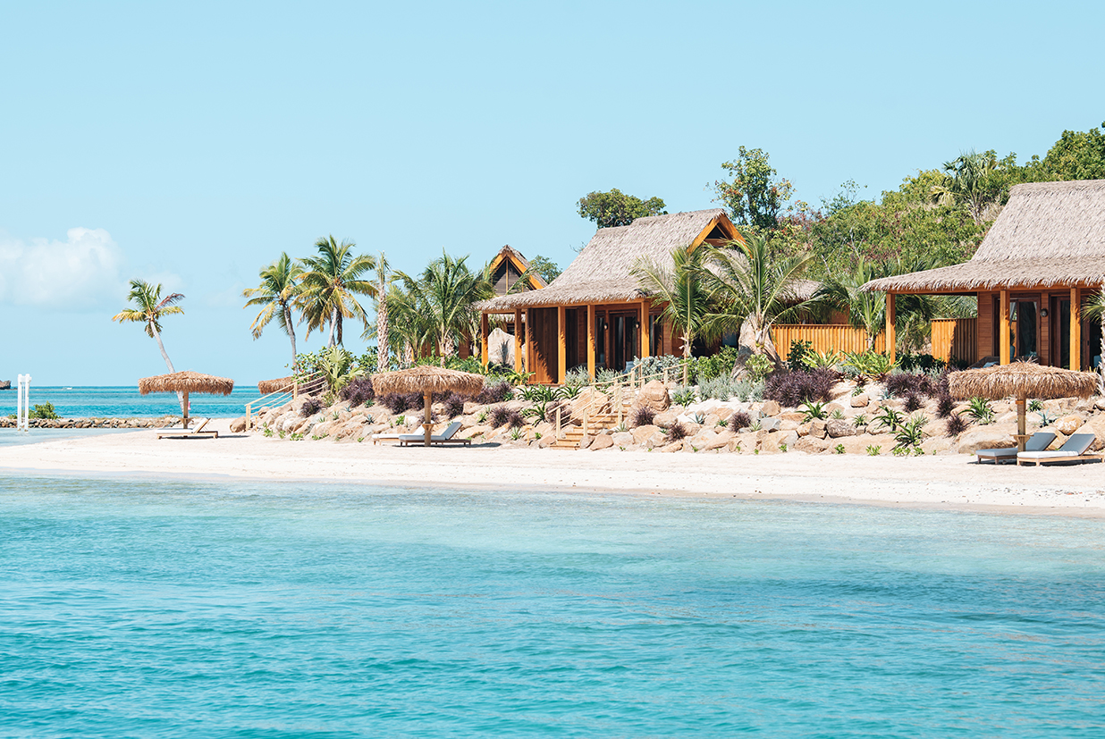 a beach with a hut and palm trees