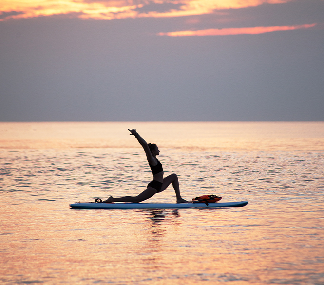 a woman on a surfboard doing yoga