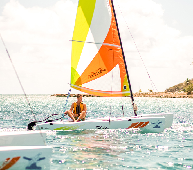 a man sitting on a small sailboat