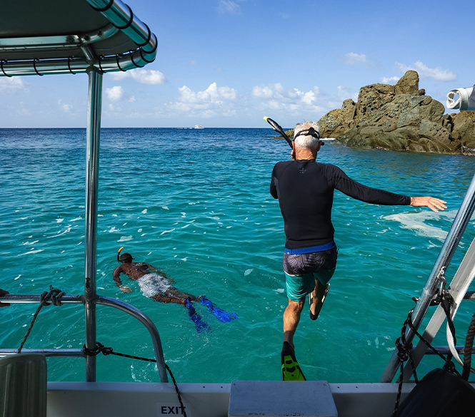 a man jumping into the water with a snorkel