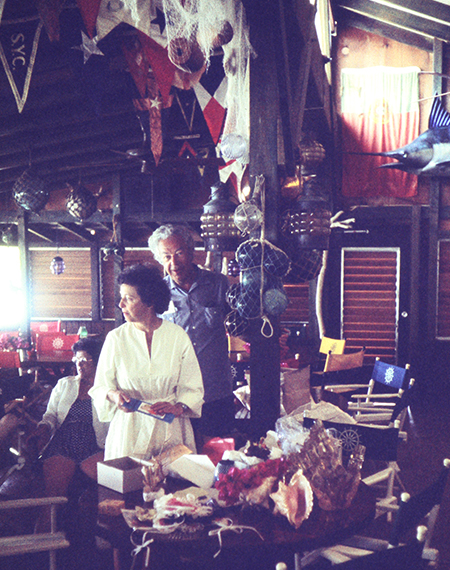 a man and woman standing in a room with objects and flags