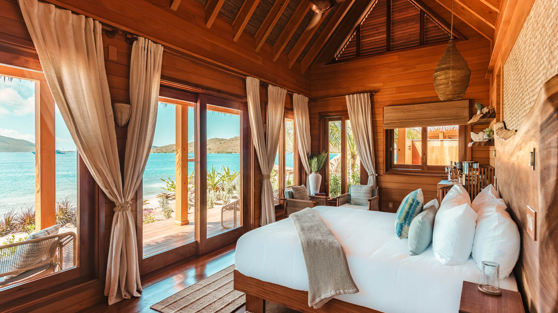 a room with a bed and a view of the ocean