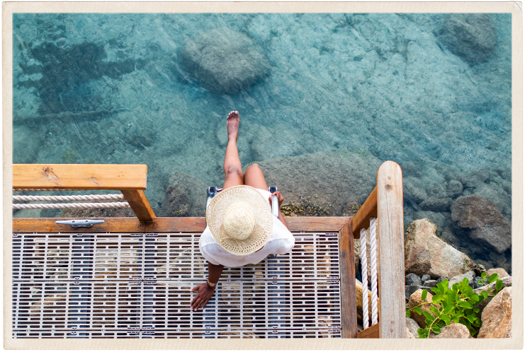 a woman sitting on a dock overlooking water