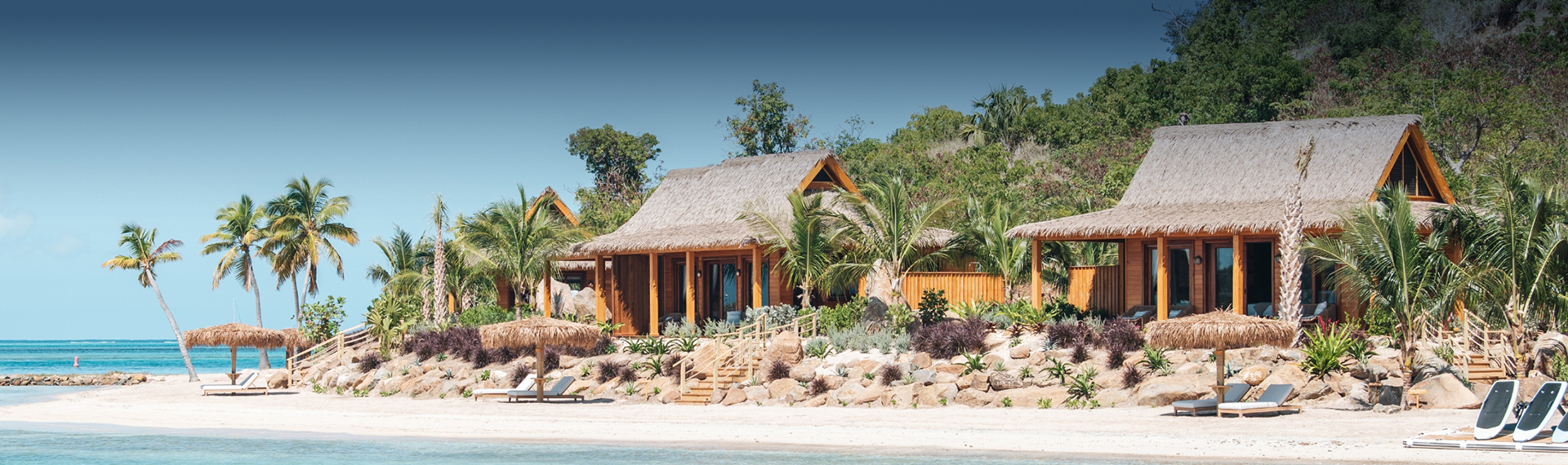 a house with a thatched roof and palm trees
