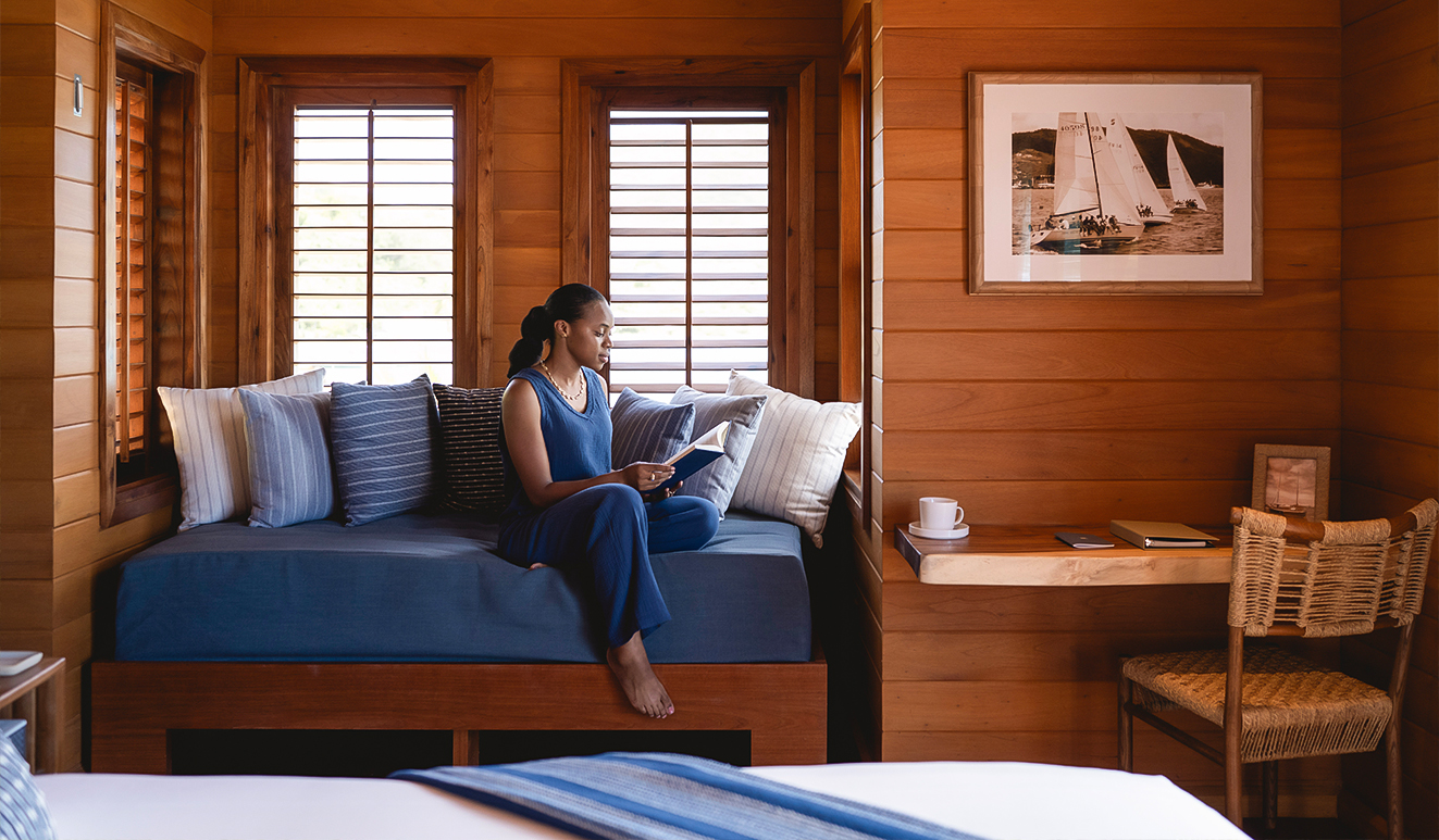 a woman sitting on a bed reading a book