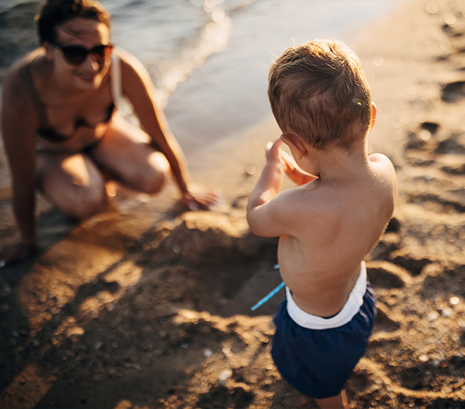 a woman and child playing on the beach