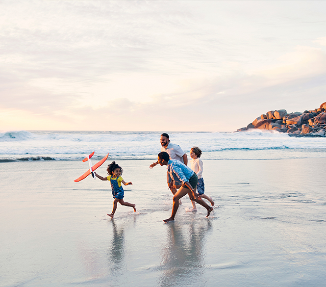 a group of people running on a beach