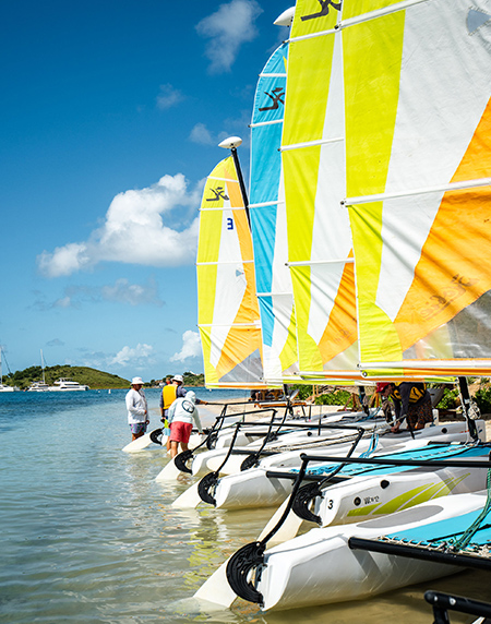 a group of people standing next to sailboats