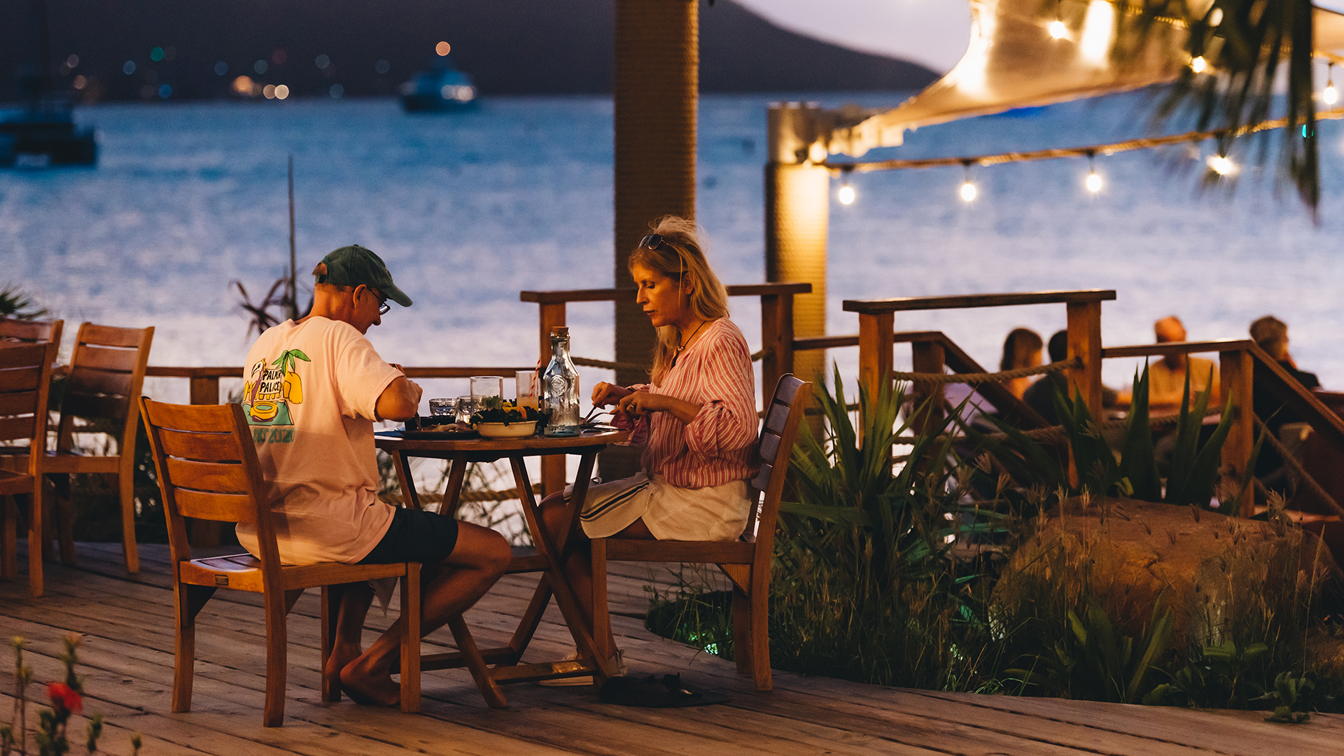 a man and woman sitting at a table outside