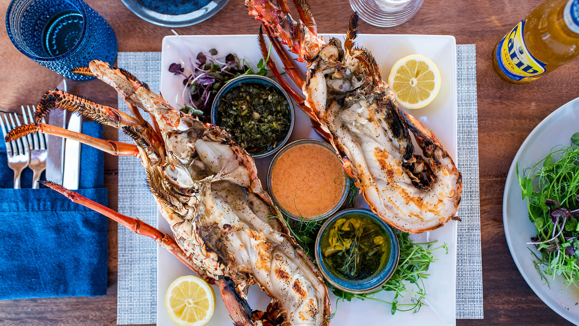 a plate of food with a lobster and sauces