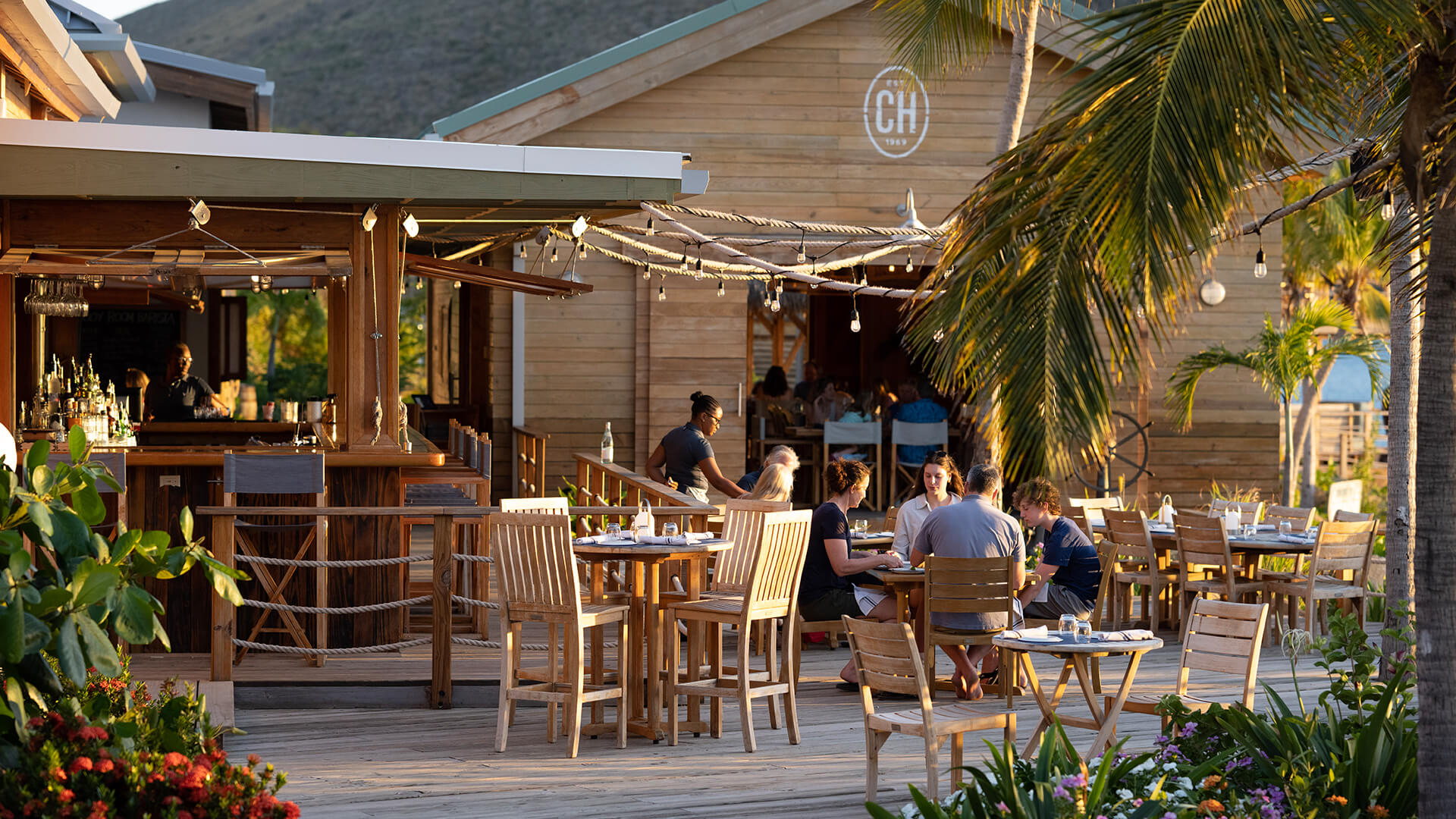 a group of people sitting at tables outside a restaurant