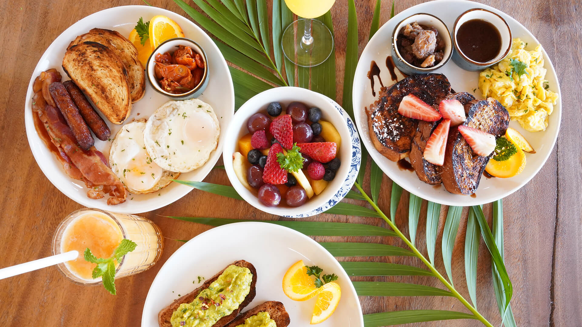 a table with plates of food and a glass of juice