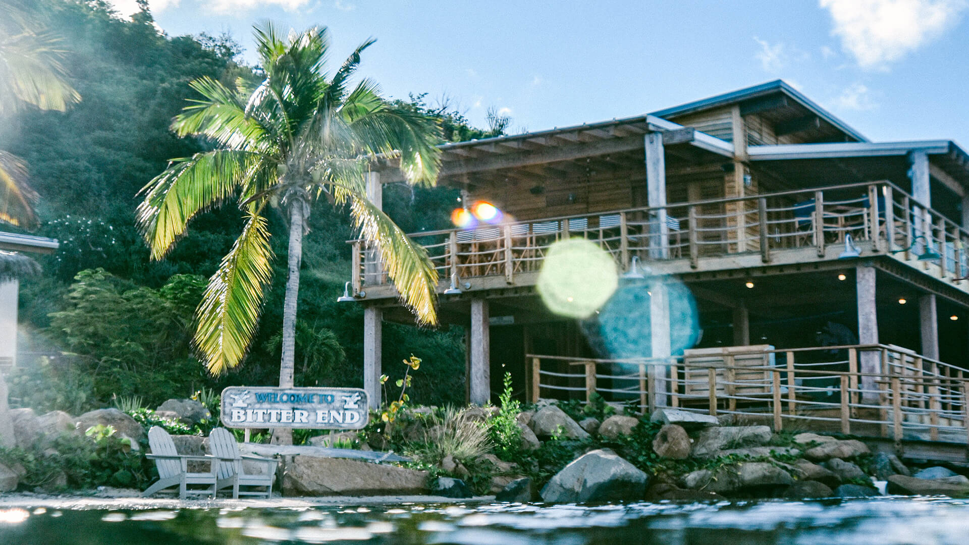 a building with a palm tree and a sign on the side of it