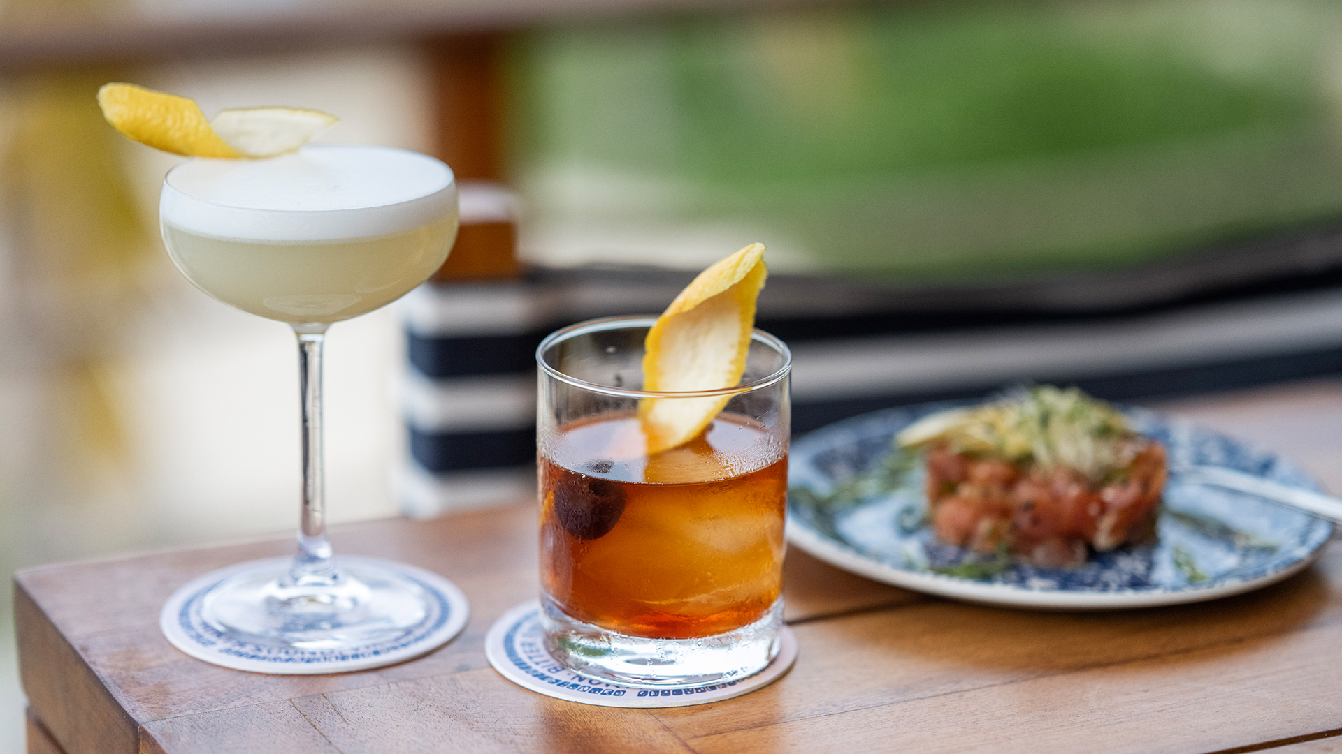 a glass of drink with a slice of fruit on top of it