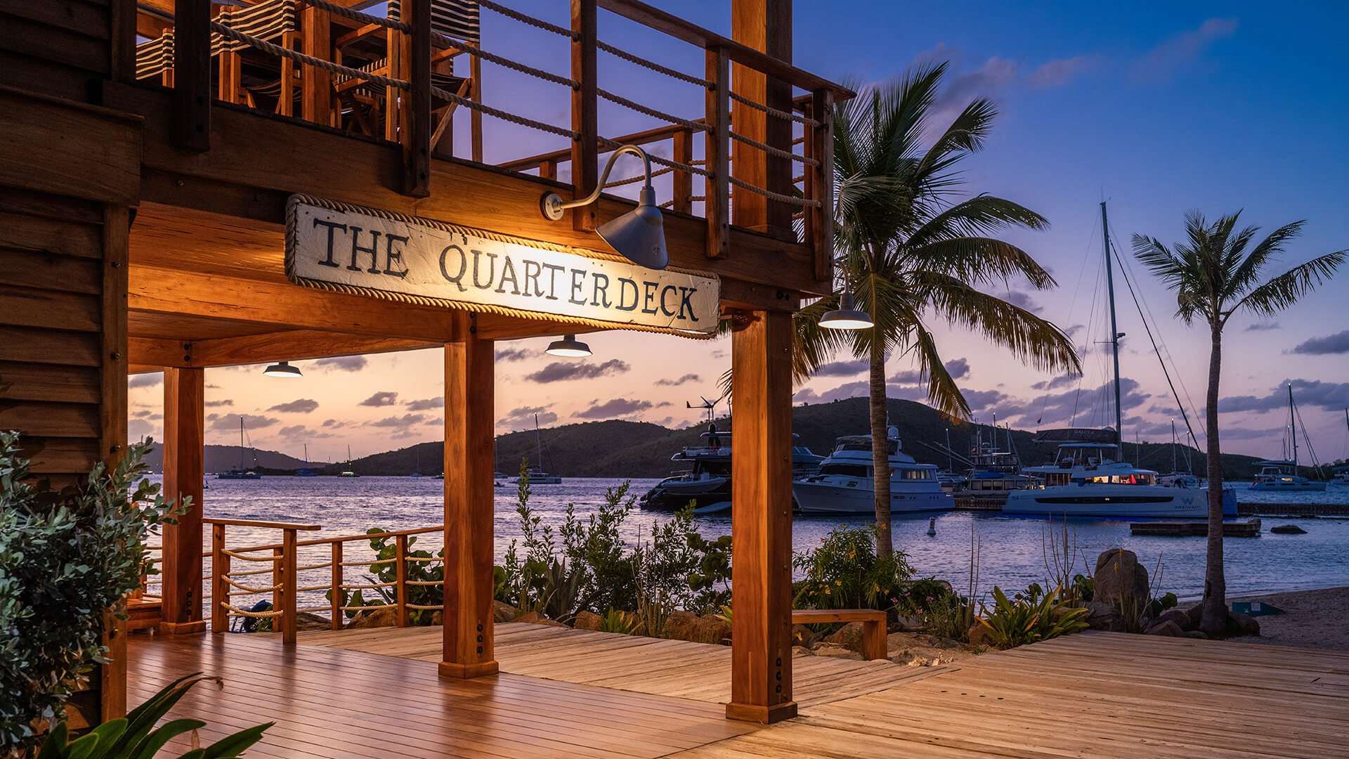 a dock with a sign and palm trees