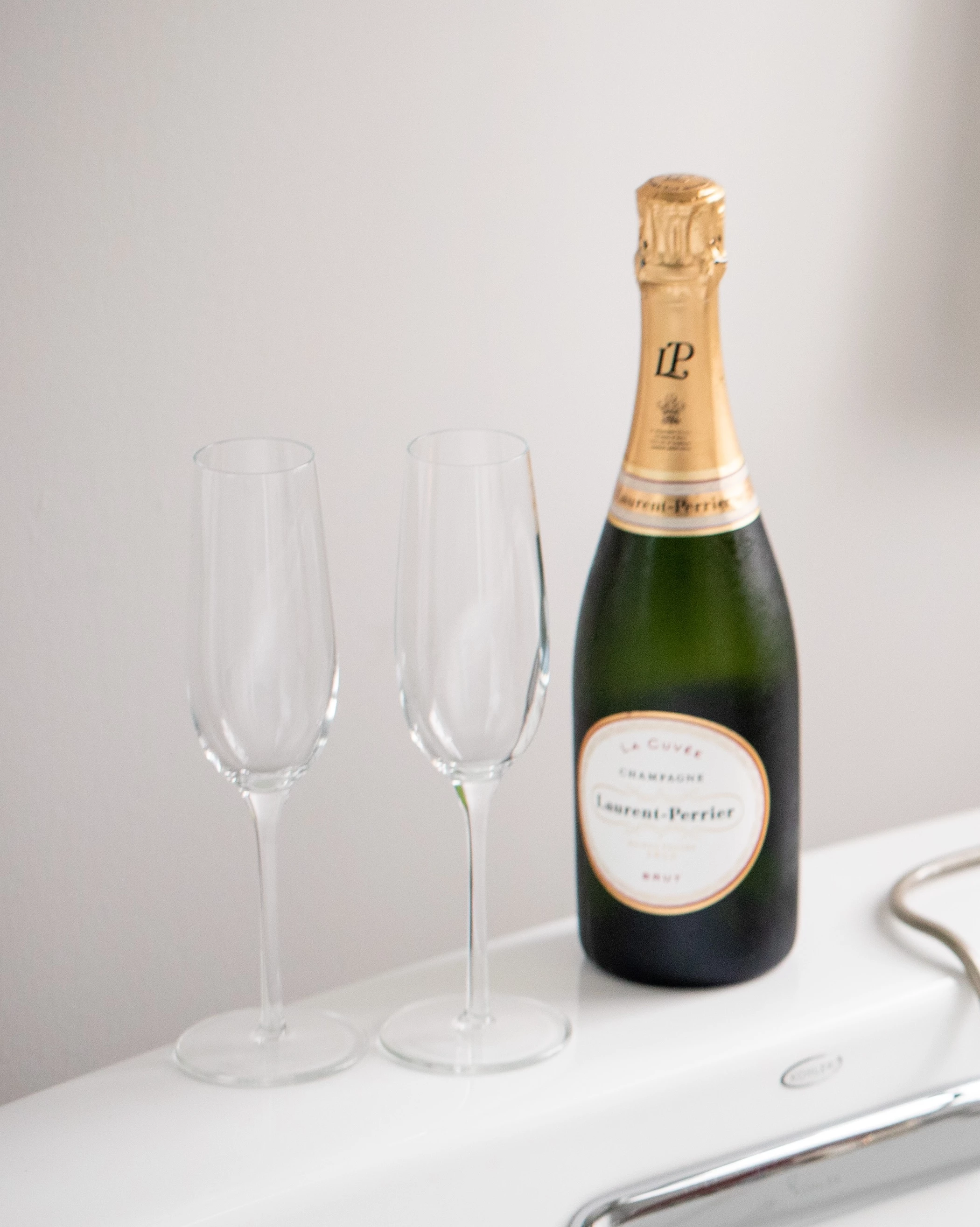 a bottle of champagne next to two empty wine glasses
