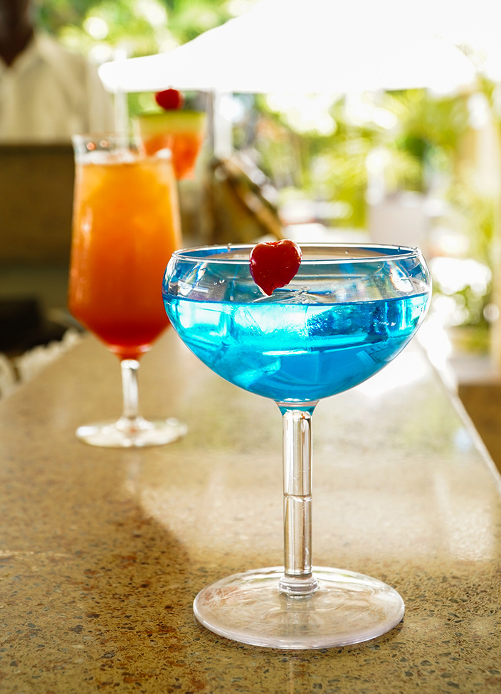a blue drink with a red heart in a glass