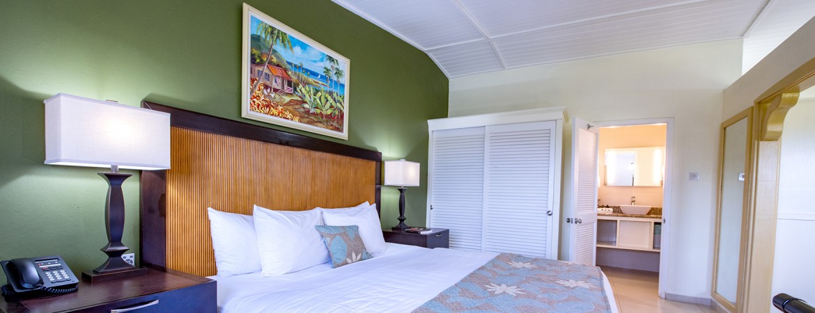 a bed with a lamp and a painting on the wall