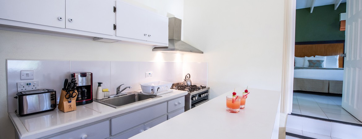 a kitchen with a sink and two glasses of drinks